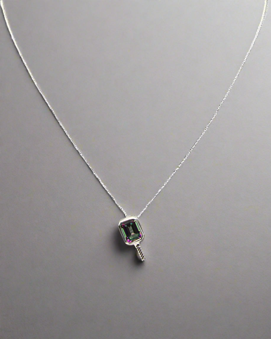 a beautiful pickleball shaped necklace set centrally with a mystic topaz gemstone that is a beautiful purple green color on a silver chain