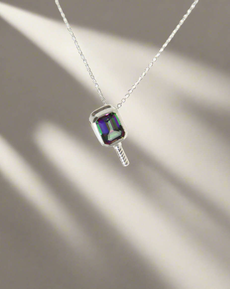 Necklace with a pendant featuring a colorful mystic topaz gemstone set in a pickleball style pendant on a white background