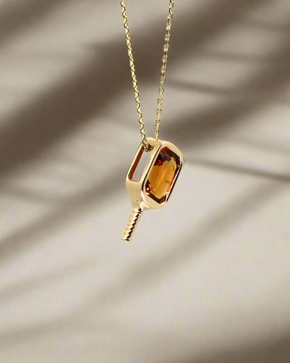 14k yellow Gold necklace with a pickleball paddle pendant featuring an orange citrine gemstone bezel set