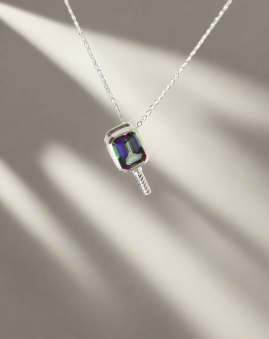 Necklace with a pendant featuring a colorful mystic topaz gemstone set in a pickleball style pendant on a white background